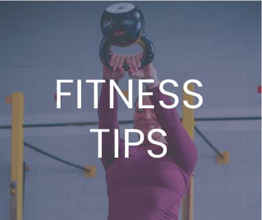Woman lifting a kettlebell overhead in the gym